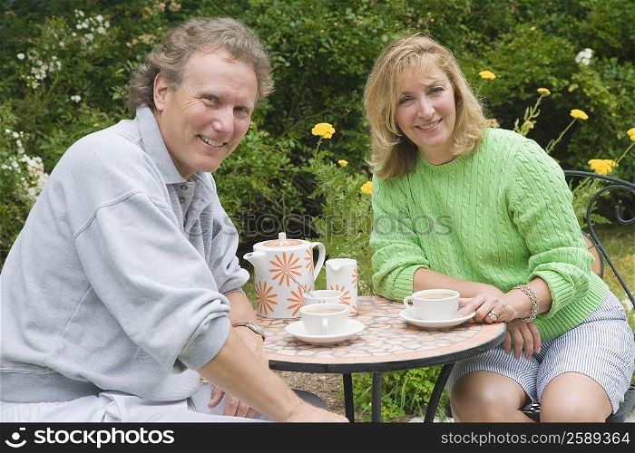 Portrait of a mature couple sitting at a table and drinking tea