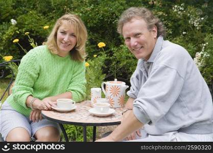 Portrait of a mature couple sitting at a table and drinking tea