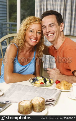 Portrait of a mature couple sitting at the breakfast table and smiling