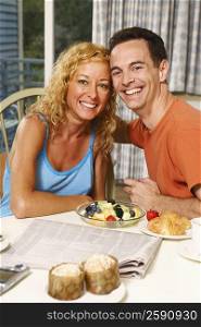 Portrait of a mature couple sitting at the breakfast table and smiling