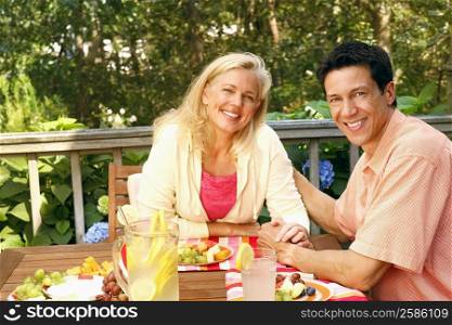 Portrait of a mature couple sitting at the table and smiling
