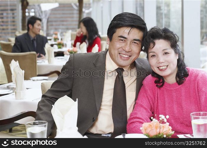 Portrait of a mature couple sitting in a restaurant smiling