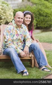 Portrait of a mature couple sitting on a lounge chair and smiling