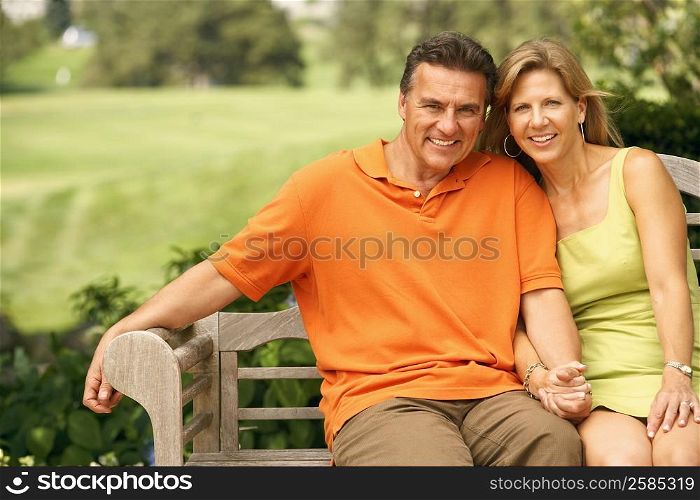Portrait of a mature couple sitting on a park bench and smiling