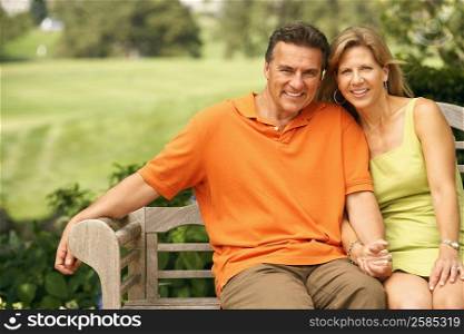 Portrait of a mature couple sitting on a park bench and smiling
