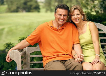 Portrait of a mature couple sitting on a park bench and smiling