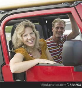 Portrait of a mature couple smiling in a jeep