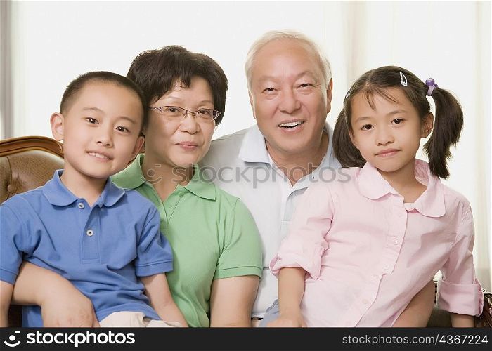 Portrait of a mature couple smiling with their grandchildren