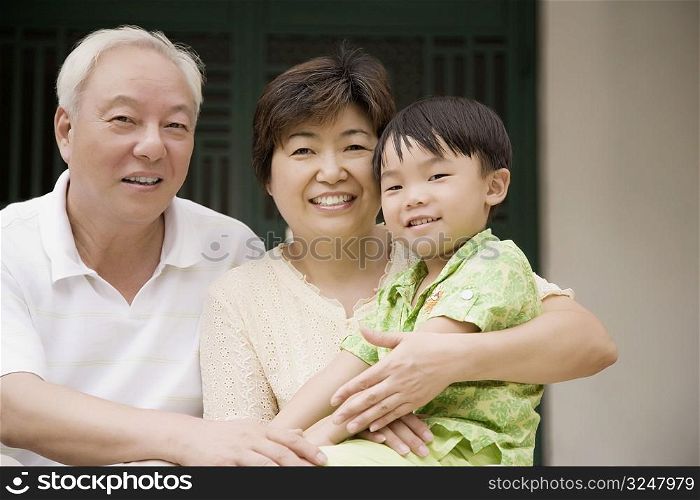 Portrait of a mature couple smiling with their grandson