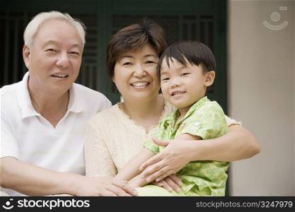 Portrait of a mature couple smiling with their grandson