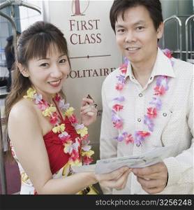 Portrait of a mature couple standing and holding an airplane ticket