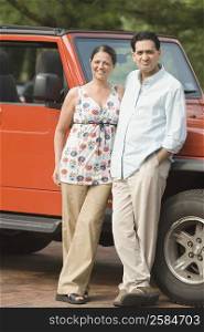 Portrait of a mature couple standing near a car