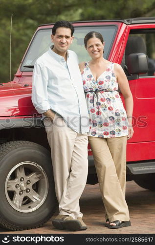 Portrait of a mature couple standing near a car