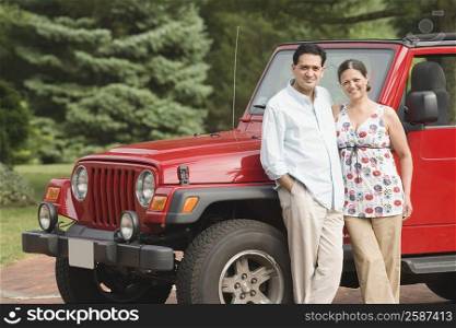 Portrait of a mature couple standing near a car