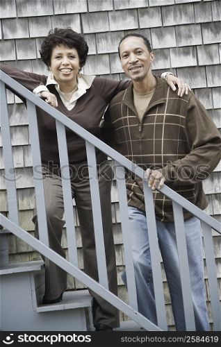 Portrait of a mature couple standing on a staircase and smiling