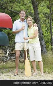 Portrait of a mature couple standing together with an oar