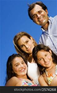 Portrait of a mature couple standing with their two daughters and smiling
