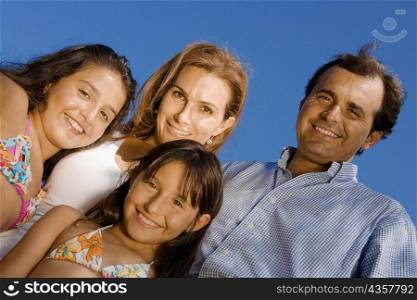 Portrait of a mature couple standing with their two daughters and smiling