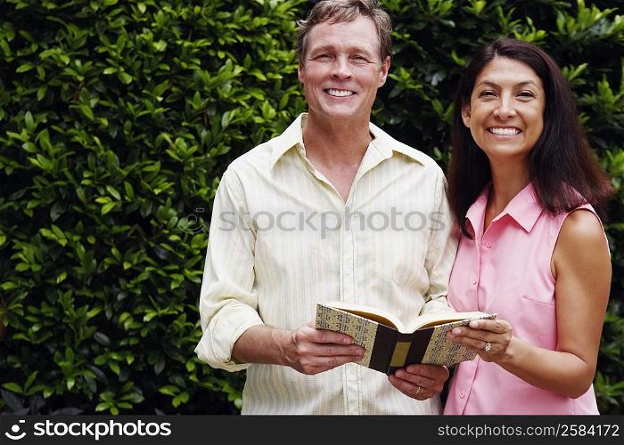 Portrait of a mature couple with a book in their hands standing together
