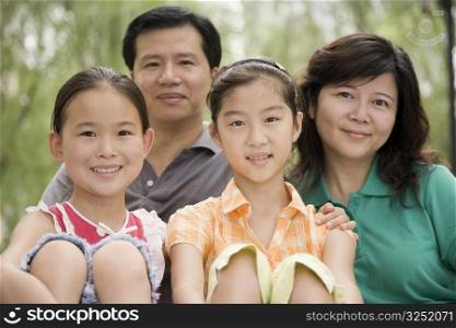 Portrait of a mature couple with their daughters smiling