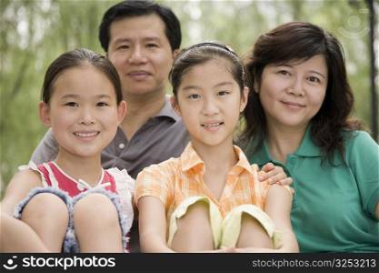 Portrait of a mature couple with their daughters smiling