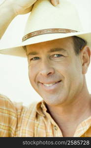 Portrait of a mature man adjusting his hat and smiling