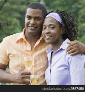 Portrait of a mature man and a mid adult woman holding glasses of wine and smiling