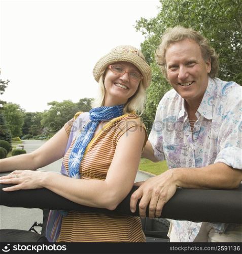 Portrait of a mature man and a mid adult woman in a convertible car and smiling