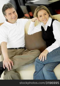 Portrait of a mature man and a mid adult woman sitting on a couch and smiling