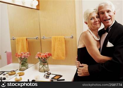 Portrait of a mature man and a senior woman embracing each other in the bathroom