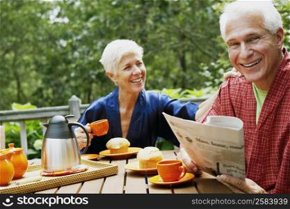 Portrait of a mature man and a senior woman sitting at the table and smiling
