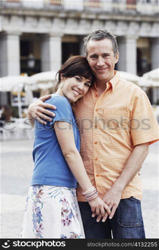 Portrait of a mature man and a young woman embracing each other