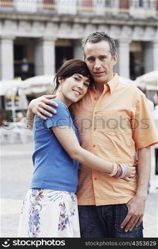 Portrait of a mature man and a young woman embracing each other