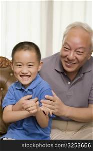 Portrait of a mature man and his grandson smiling