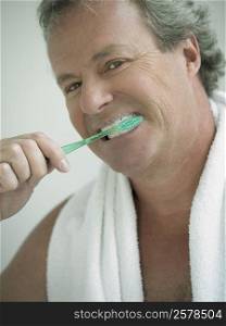 Portrait of a mature man brushing his teeth