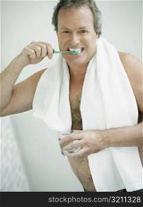 Portrait of a mature man brushing his teeth