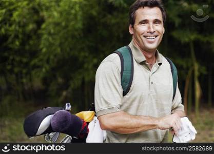 Portrait of a mature man carrying a golf bag