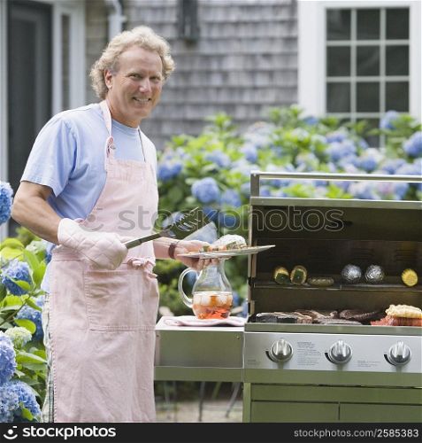 Portrait of a mature man cooking food on a barbecue grill