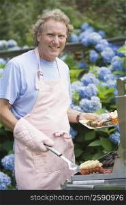 Portrait of a mature man cooking food on a barbecue grill