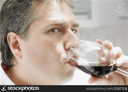 Portrait of a mature man drinking a glass of red wine