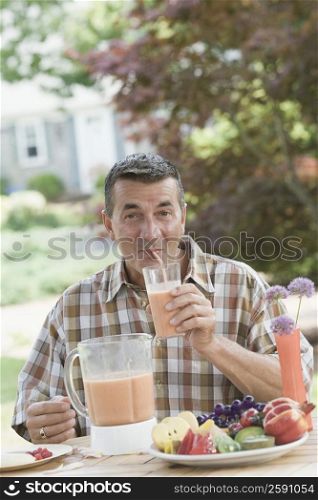 Portrait of a mature man drinking juice with a drinking straw
