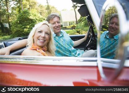 Portrait of a mature man driving a convertible car with a mature woman sitting beside him