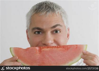 Portrait of a mature man eating a slice of watermelon