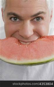Portrait of a mature man eating a slice of watermelon
