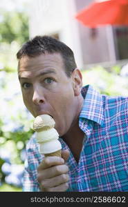 Portrait of a mature man eating an ice cream cone