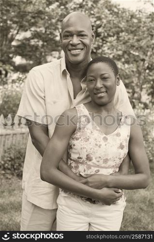 Portrait of a mature man embracing a mid adult woman and smiling