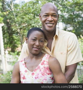 Portrait of a mature man embracing a mid adult woman and smiling