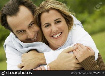 Portrait of a mature man embracing a mid adult woman from behind