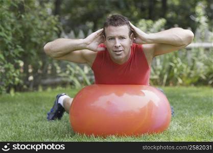 Portrait of a mature man exercising with a ball