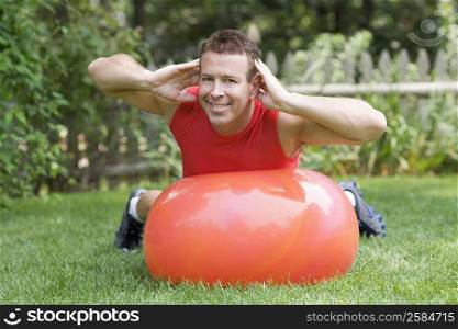 Portrait of a mature man exercising with a ball